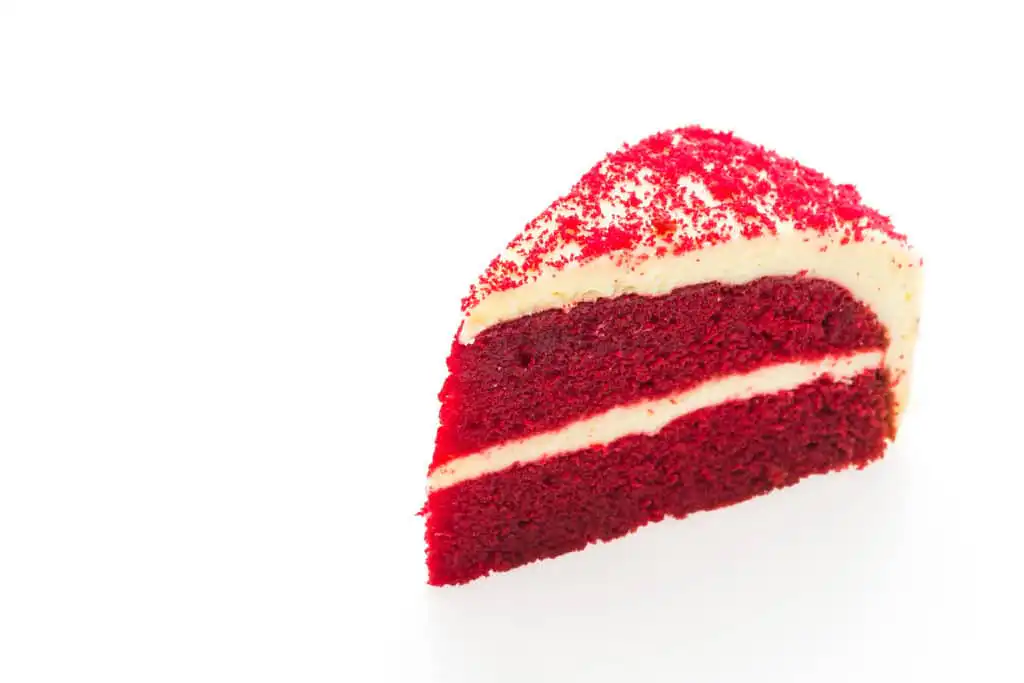 Close-up of a red velvet cake slice with cream cheese frosting.