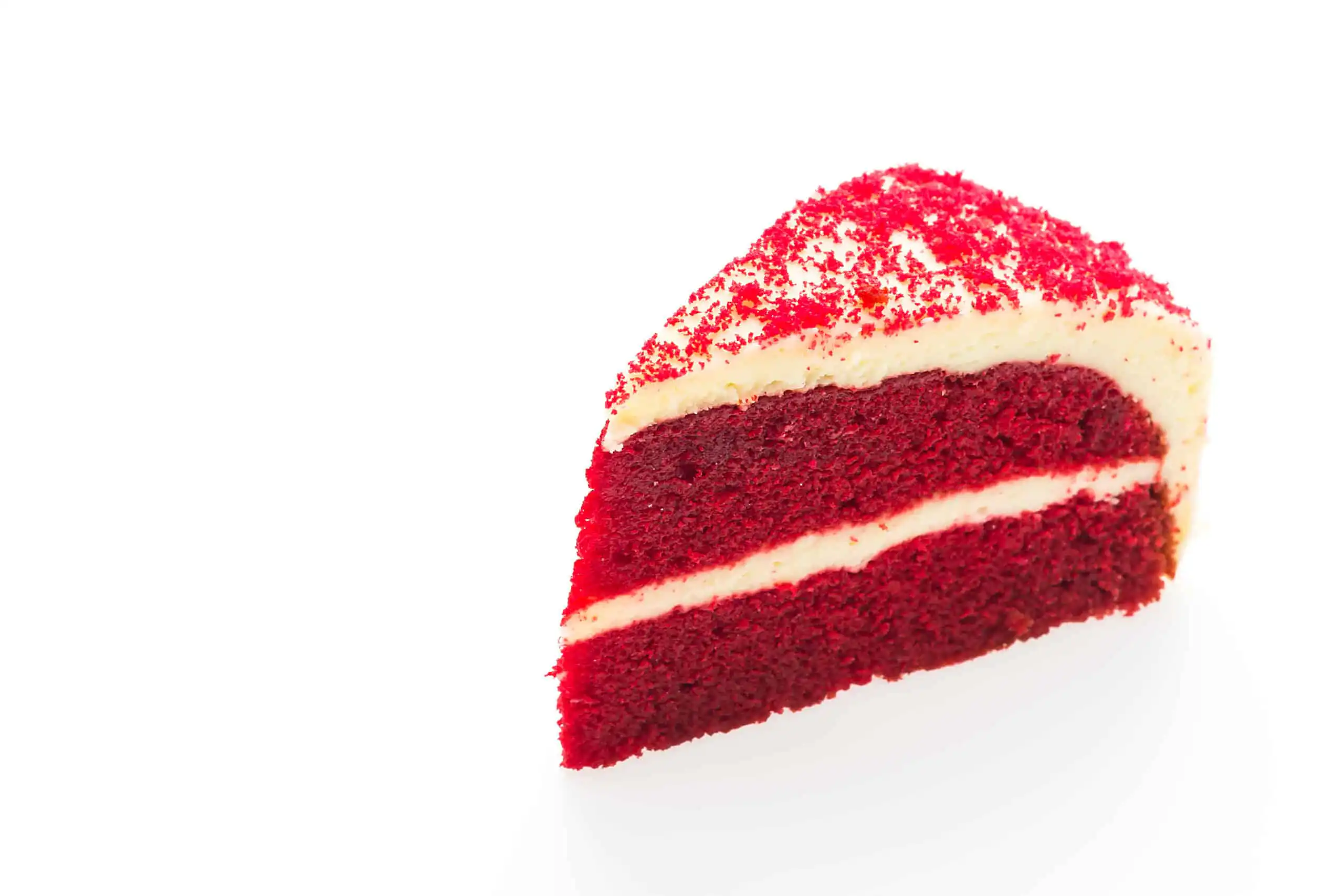 Close-up of a red velvet cake slice with cream cheese frosting.