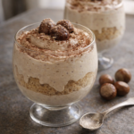 Ultra-realistic food photography of a chestnut cream mousse dessert in a glass, smooth and airy texture, light cocoa dusting on top, warm natural window light, minimal elegant table setting, authentic homemade look, iPhone 15 Pro style, shallow depth of field. Aspect ratio 16:9.